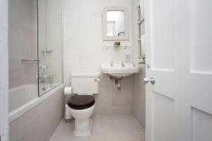 a white bathroom with a toilet and a sink at Stylish City Centre Apartment - Bath in Bath