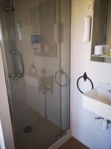Un baño con ducha de cristal y lavabo. en Apartamento El Baco entre viñedos, en Arriate