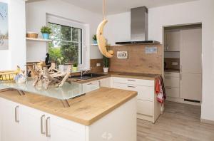 a kitchen with white cabinets and a glass counter top at Ferienhaus ELSA Kinder erst ab 12 in Dierhagen