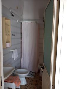 uma casa de banho com um chuveiro, um lavatório e um WC. em Casa La Perla em Ischia