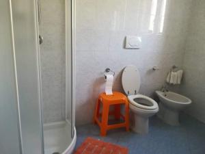 uma casa de banho com um WC, um chuveiro e um banco em Casa La Perla em Ischia