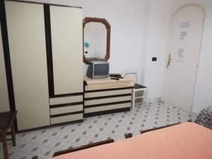 um quarto com um espelho e uma cómoda com uma televisão em Casa La Perla em Ischia