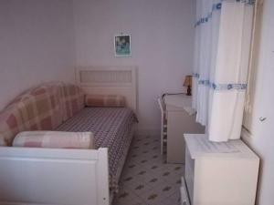 een kleine slaapkamer met een bed en een wastafel bij Casa La Perla in Ischia