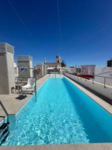 a swimming pool on the roof of a building at Goodnight Cádiz Apartments in Cádiz