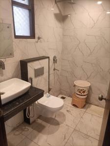 a bathroom with a white toilet and a sink at Hotel Tela Suite A Family Hotel Near Delhi Airport in New Delhi