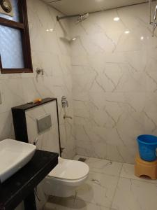 Hotel Tela Suite A Family Hotel Near Delhi Airport في نيودلهي: حمام به مرحاض أبيض ومغسلة