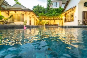 een zwembad voor een huis met een roze speeltje in het water bij Villa Đà nẵng Gần Biển - Biệt Thự Gần Biển in Da Nang