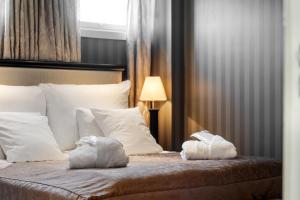 a bedroom with a bed with two towels on it at Frichs Hotel Hamar in Hamar +82 photos