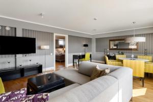 a living room with a couch and a dining room at Frichs Hotel Hamar in Hamar