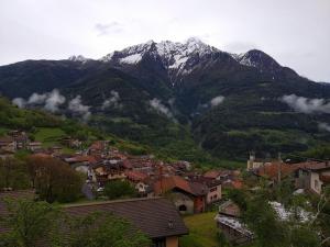 una ciudad frente a una montaña con nieve en hotel quai, en Monno