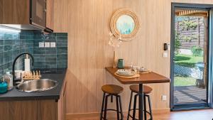 a kitchen with a sink and a counter with stools at L'Escale - Les Lodges de Praly in Les Ollières-sur-Eyrieux