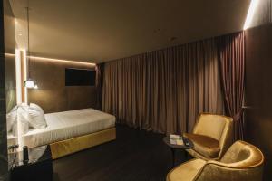 una camera d'albergo con letto e sedia di Hotel Touring a Ferrara