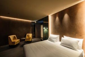 una camera d'albergo con un letto e due sedie di Hotel Touring a Ferrara