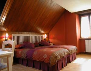 1 dormitorio con 1 cama grande y techo de madera en Casa Aguerre, en Villanueva de Aézcoa