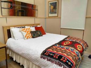 a bedroom with a bed with colorful pillows on it at Sky gazer cabin in the woods in Dublin