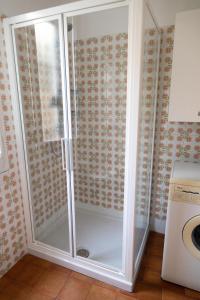 a glass shower in a bathroom next to a washing machine at Posa in Santa Margherita Ligure