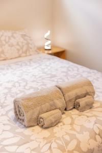 uma toalha deitada numa cama num quarto em Back Garden Flat with Free On Street Parking and Fiber WIFI - 15 mins to Ferry, Stadium, CBD em Wellington