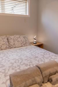 Back Garden Flat with Free On Street Parking and Fiber WIFI - 15 mins to Ferry, Stadium, CBD في ويلينغتون: غرفة نوم بسرير ونافذة