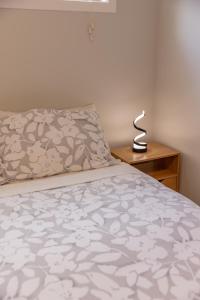 - une chambre avec un lit et une lampe sur une table de chevet dans l'établissement Back Garden Flat with Free On Street Parking and Fiber WIFI - 15 mins to Ferry, Stadium, CBD, à Wellington