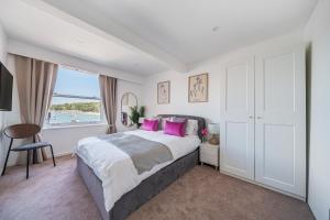 a bedroom with a large bed with pink pillows at N° 31 The Salcombe in Salcombe