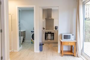a kitchen with a microwave and a table with a microwave at Back Garden Flat with Free On Street Parking and Fiber WIFI - 15 mins to Ferry, Stadium, CBD in Wellington