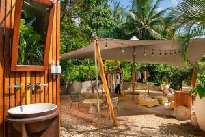 a patio with an umbrella and a table and chairs at Zuri Zanzibar in Kendwa