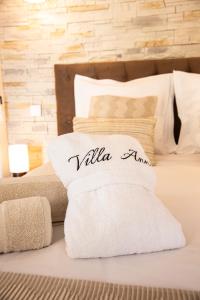 a bed with a white pillow with the word validaamn at Chambre d’hôtes Corse Villa Anna in Vescovato