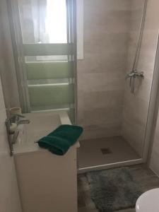 a bathroom with a shower and a green towel at Chalet con jardín y parking Vinaros playa in Vinarós