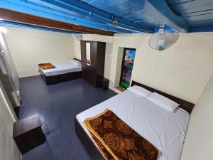 a bedroom with two beds and a blue ceiling at Greene Villa in Palakkad