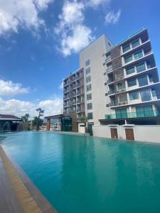 una gran piscina frente a un edificio en โรงแรมออร่า สงขลา, en Hat Yai