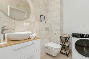 a bathroom with a sink and a washing machine at Stylish Apartment in Gdynia Balcony & WIFI by Rent like home in Gdynia