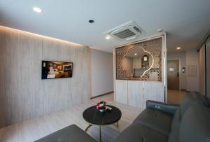 un soggiorno con divano, tavolo e specchio di โรงแรมออร่า สงขลา a Hat Yai