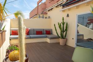 a patio with a couch and cactus on a balcony at SingularStays Roger de Flor in Valencia