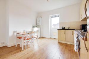 a kitchen with a table and chairs in a room at Ashley Road Apartment 3 in Poole