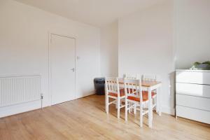 uma sala de jantar branca com uma mesa e cadeiras em Ashley Road Apartment 3 em Poole