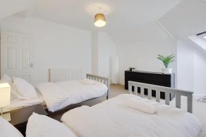 a bedroom with two beds and a desk and a table at Ashley Road Apartment 3 in Poole