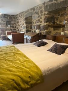 een slaapkamer met een groot bed in een kamer met stenen muren bij A Casa Carbinesa in Carbini