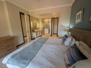 a large bed in a bedroom with a bathroom at Island View Apartment by Simply-Seychelles in Eden Island