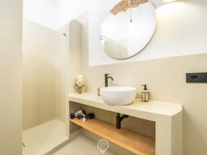 ein Badezimmer mit einem weißen Waschbecken und einem Spiegel in der Unterkunft Domus Cordis in Old Town in Cagliari