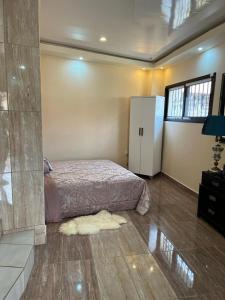 a bedroom with a bed and a refrigerator at Luxurious peaceful retreat in Freetown