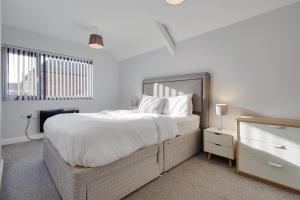 a bedroom with a large bed and a window at Ashley Road Apartments in Poole +5 photos