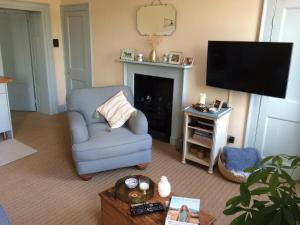 a living room with a blue chair and a television at ※ Beautiful Georgian Apartment - Central Bath ※ in Bath