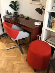 una oficina con silla roja y escritorio en BEL ET SPACIEUX APPARTEMENT AVEC TERRASSES ET JARDINS EN RDC / COUR PROCHE RER B ET TRAM BANLIEUE PARIS SUD, en Châtenay-Malabry