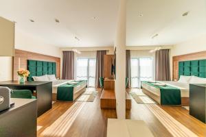 Habitación de hotel con 2 camas y escritorio en M City Aparthotel en Arad