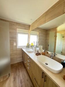 uma casa de banho com 2 lavatórios e um espelho grande em Verderena Guest Room no Barreiro
