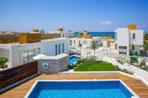 a villa with a swimming pool and a view of the ocean at Villa Indigo Paphos in Paphos City