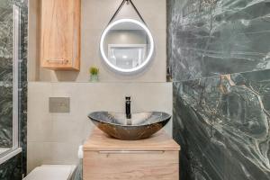 ein Badezimmer mit einem Waschbecken und einem Spiegel in der Unterkunft Apartamenty Franciszkańska in Oppeln