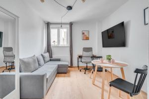 a living room with a couch and a table at Apartamenty Franciszkańska in Opole