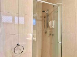 een badkamer met een douche en een glazen deur bij Cloud 9 Guest Suite in Burwood East