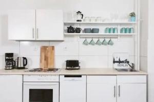 a kitchen with white cabinets and a counter top at Wonderful apartment in the heart of Berlin in Berlin